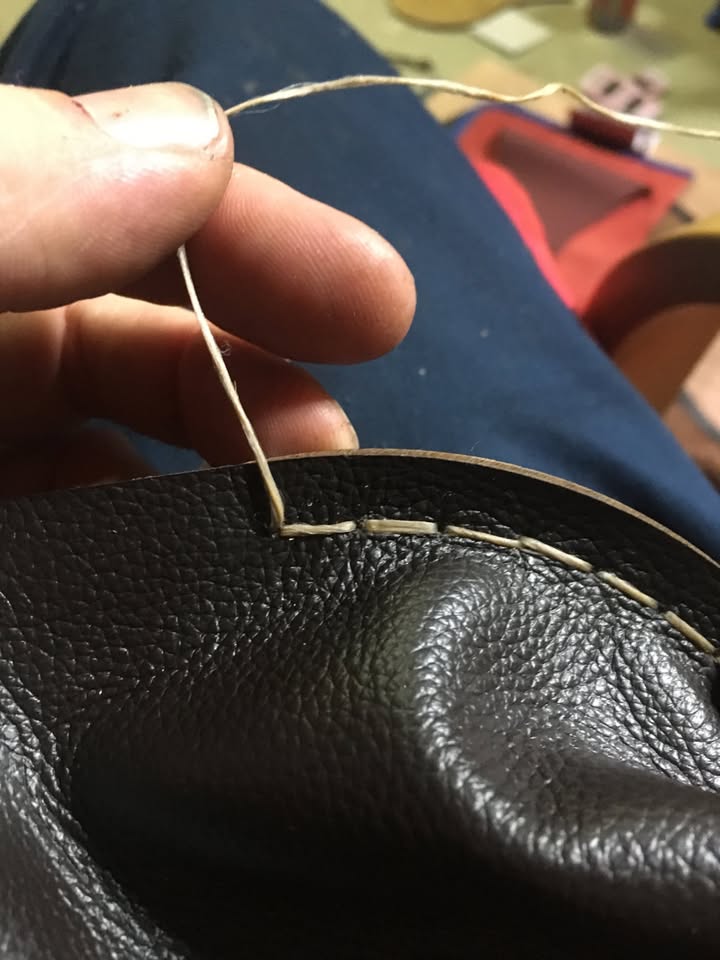 Saddle stitching at the bellows cheek.